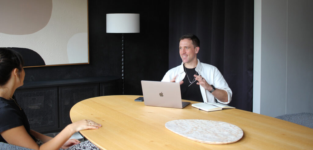 JSG VOICE's Jack Starkey-Gill gives presentation and public speaking training to a corporate professional across a boardroom table.