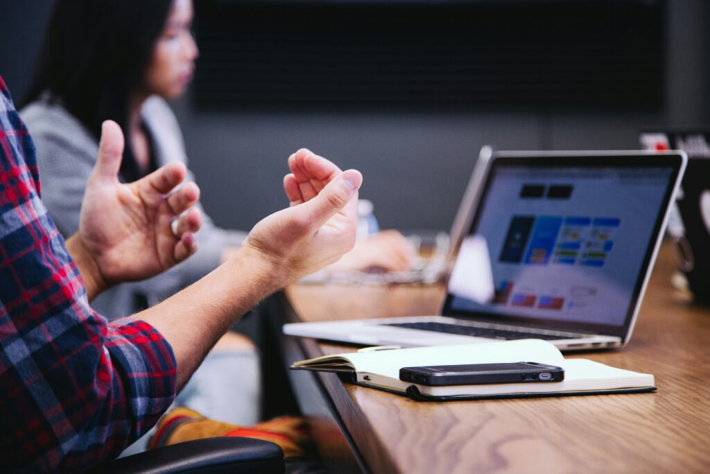 Corporate professional's hands gesticulate at acmeeting, as they effectively engage their audience with public speaking techniques learnt from JSG Voice.